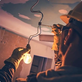 Elektryk naprawia żarówkę